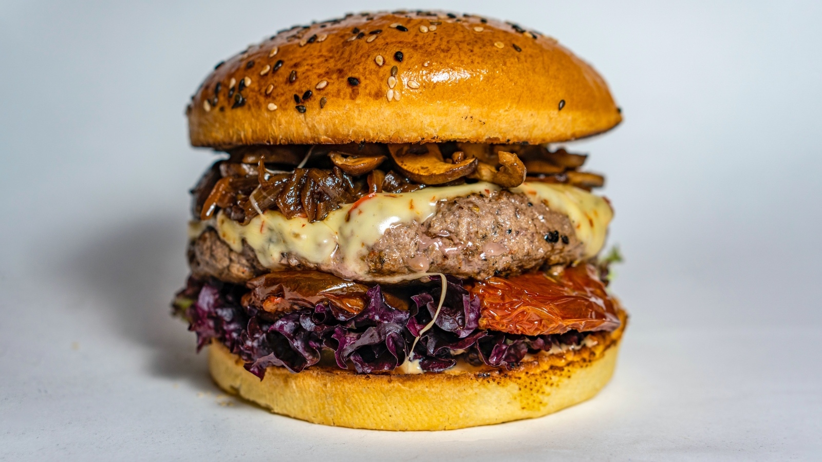 Ароматный сочный гамбургер на сером фоне крупным планом