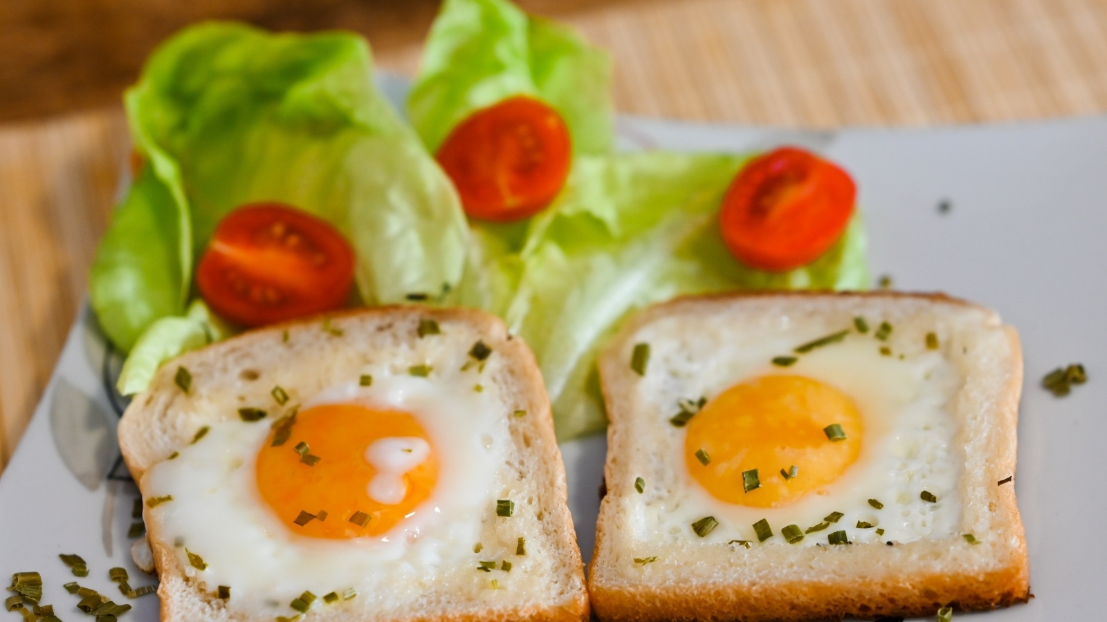 Яичница с хлебом, помидорами и листьями салата на завтрак