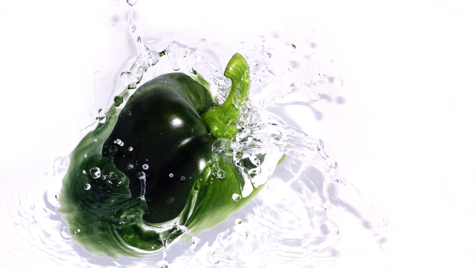 Зеленый перец в воде на белом фоне