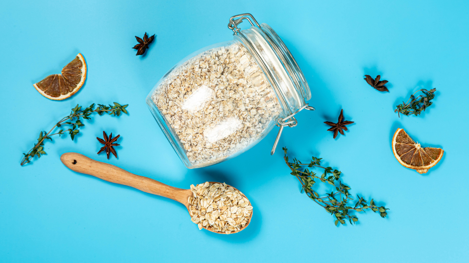 Банка с овсяными хлопьями и ложкой на голубом фоне