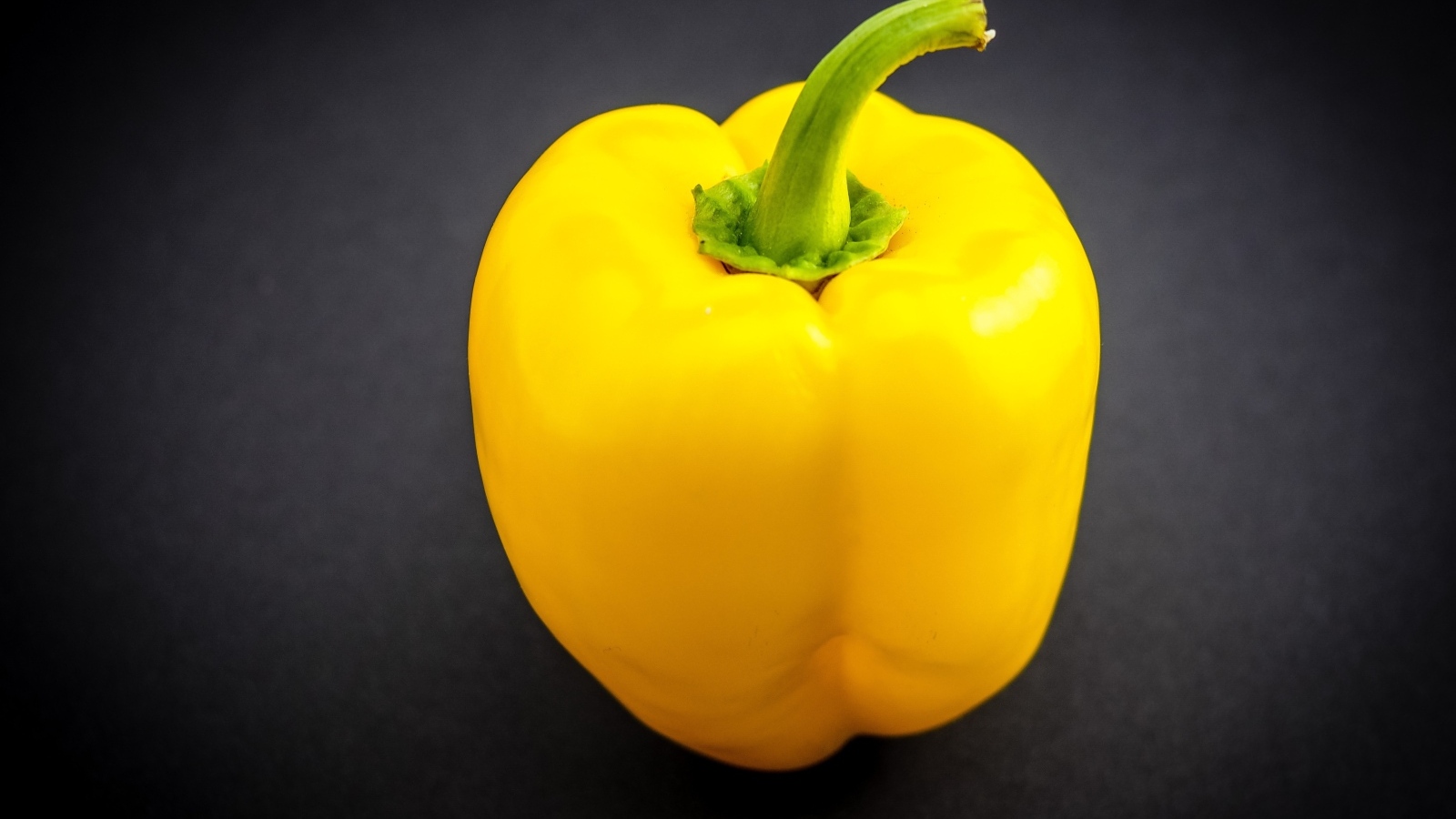 Большой желтый сладкий перец на сером фоне