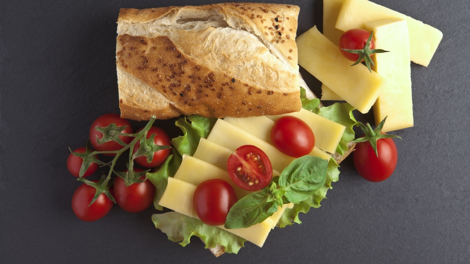 Батон с сыром и помидорами на сером фоне