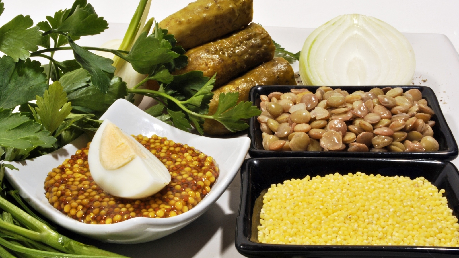 Пшено на столе с огурцами луком и горчицей