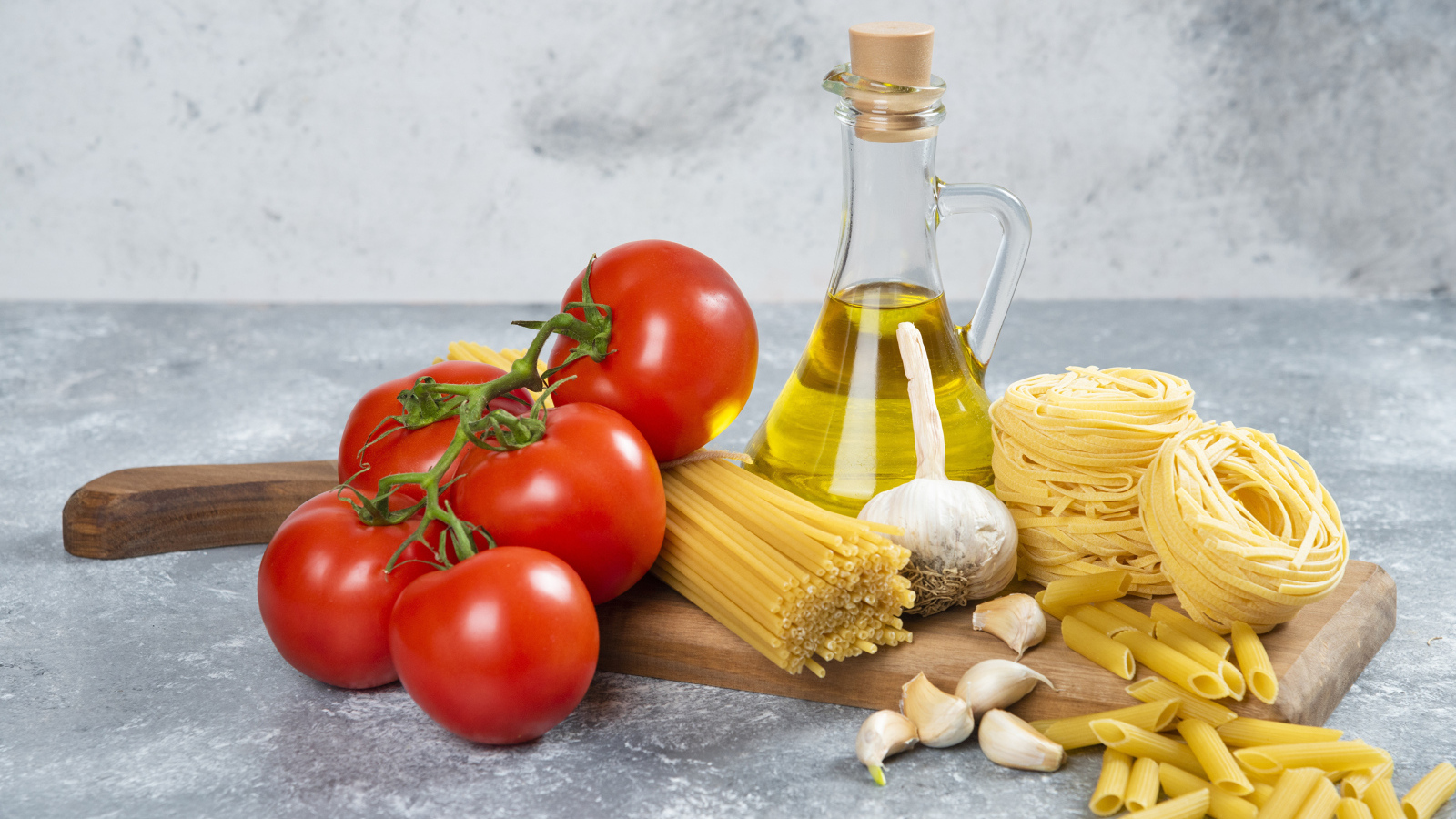 Паста, помидоры и масло на столе
