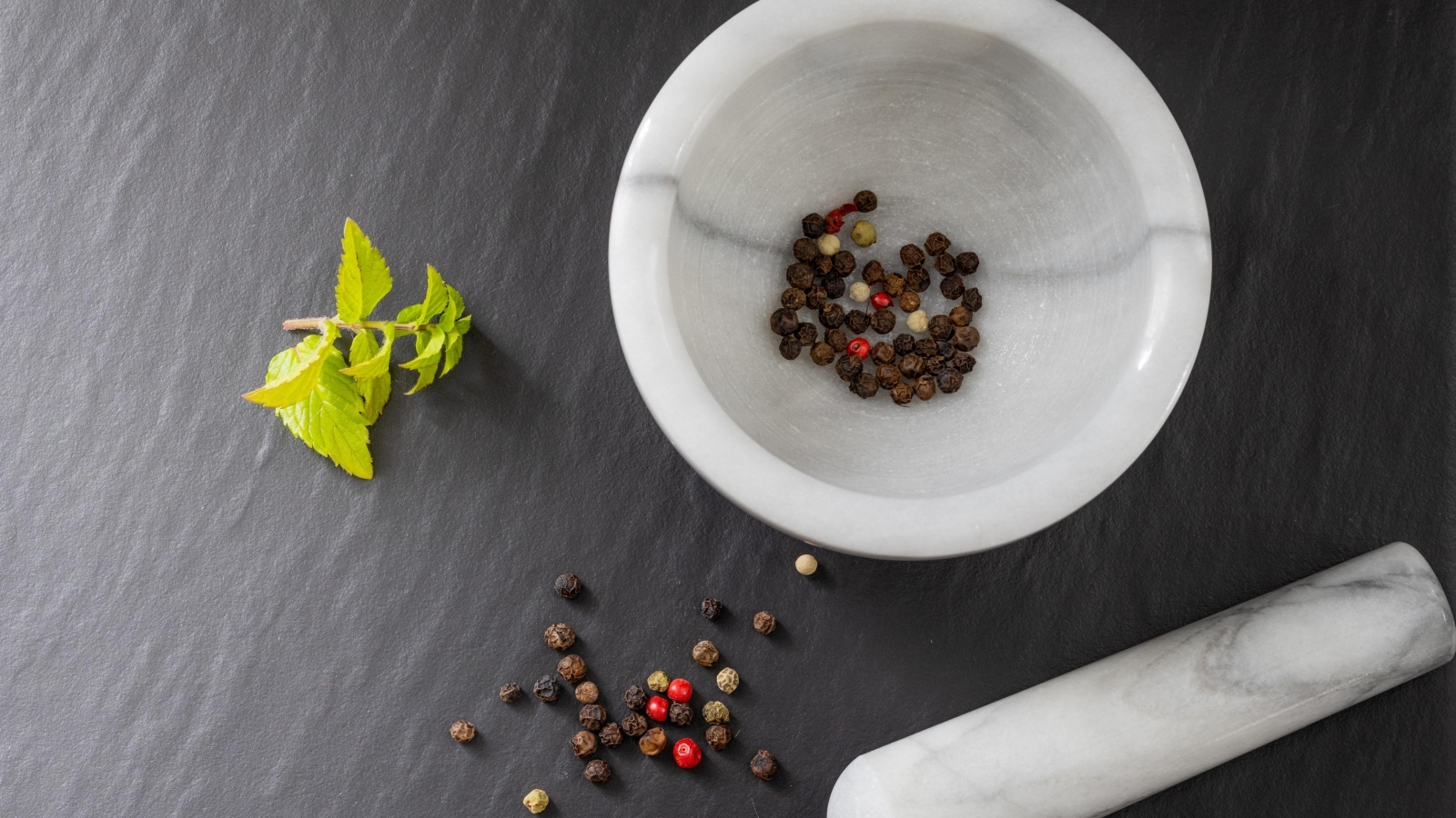 Перец горошком в ступе на сером столе