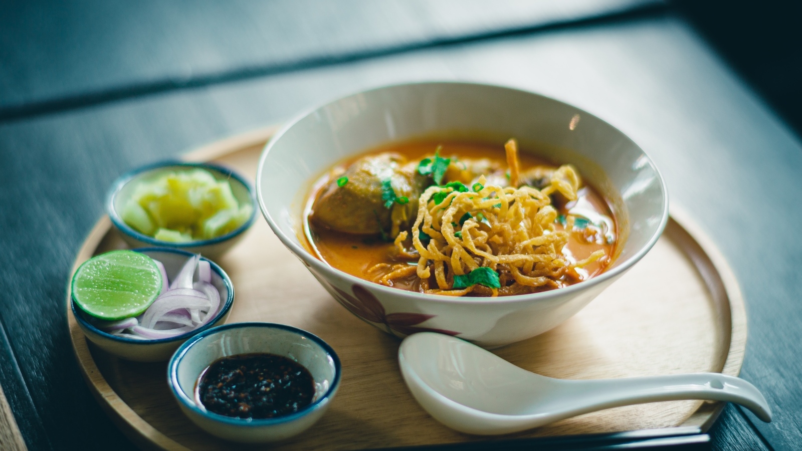 Суп рамен на подносе с луком и соусом