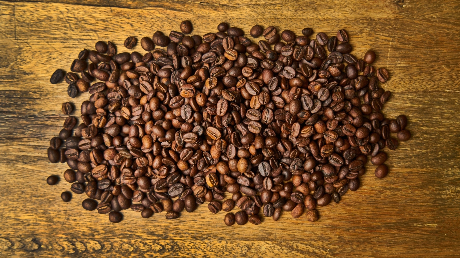 Жареные кофейные зерна на деревянном столе
