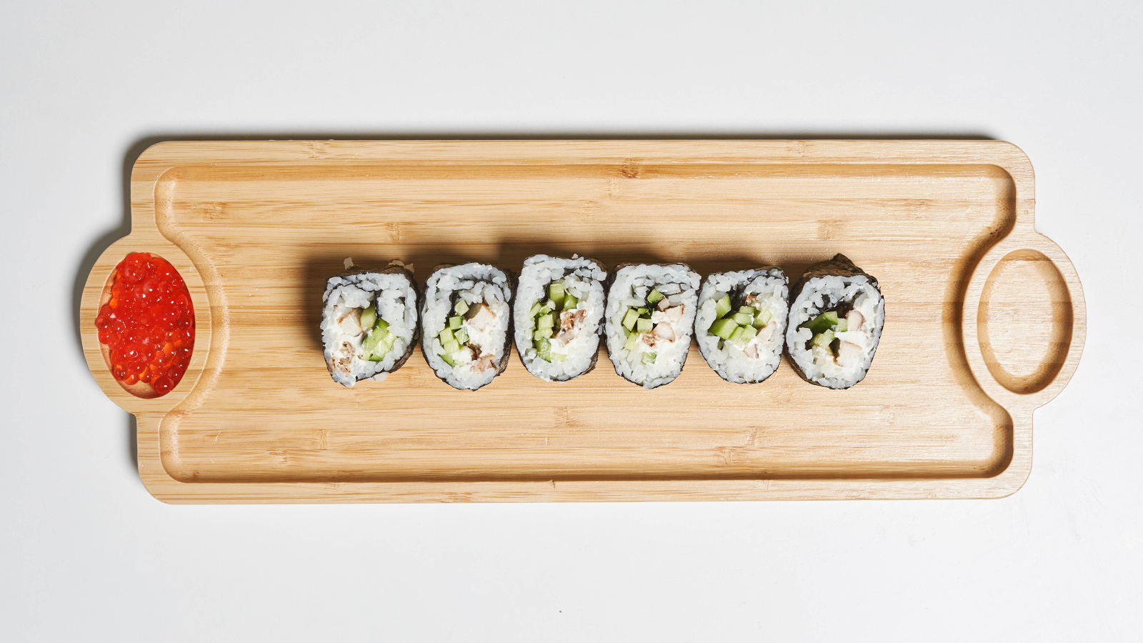 Суши на деревянной доске с  красной икрой