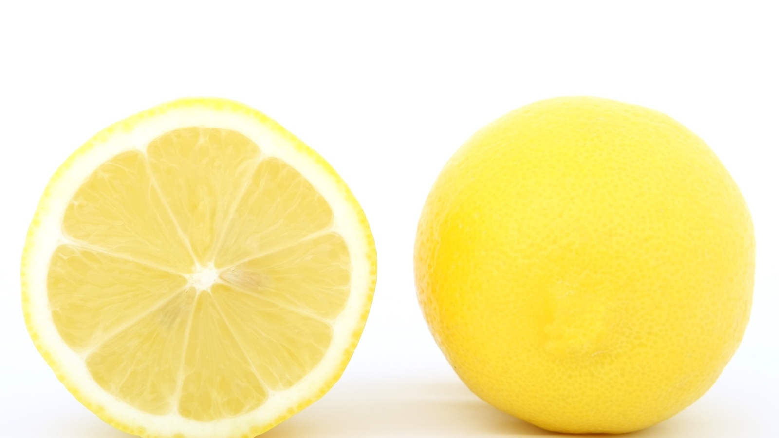 Большой желтый спелый лимон на белом фоне