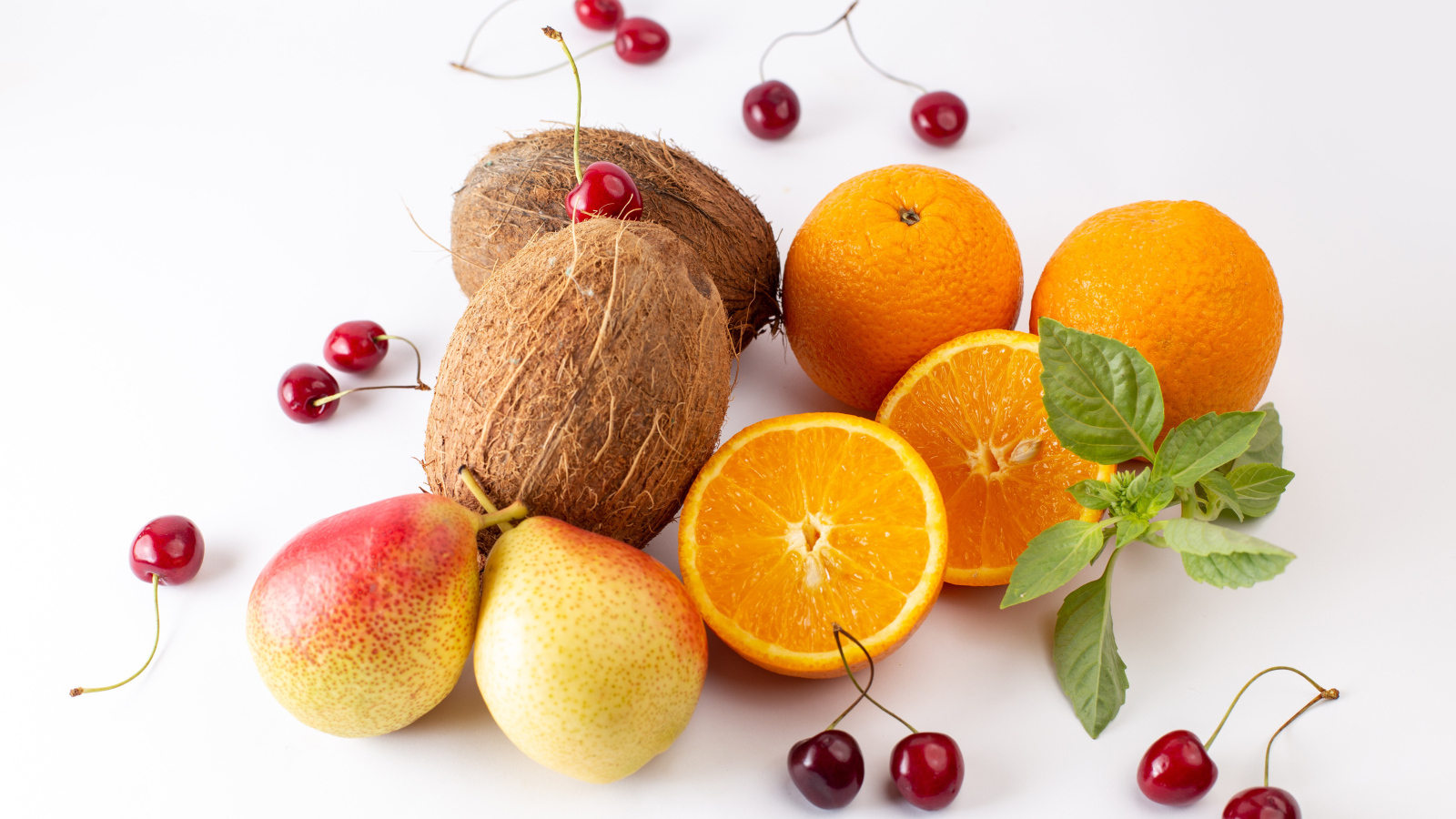 Кокосы, груши, апельсины и черешня на белом фоне
