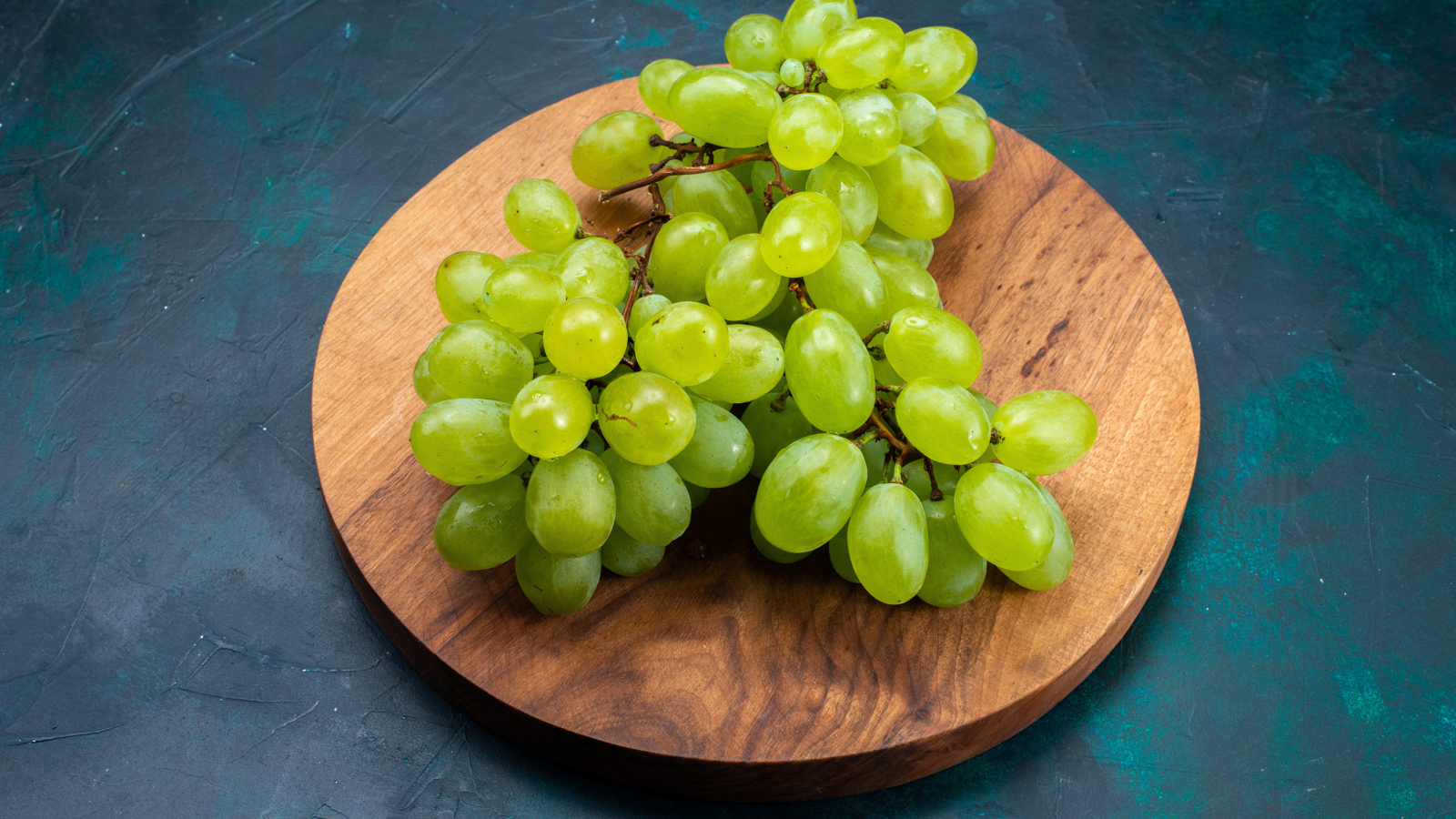 Зеленый виноград на деревянной доске