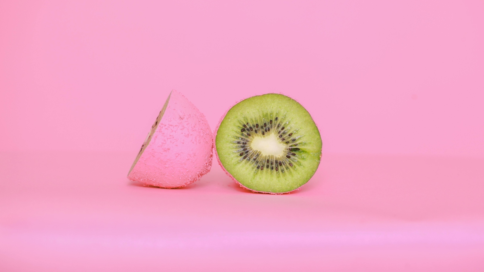 Половинки киви на розовом фоне