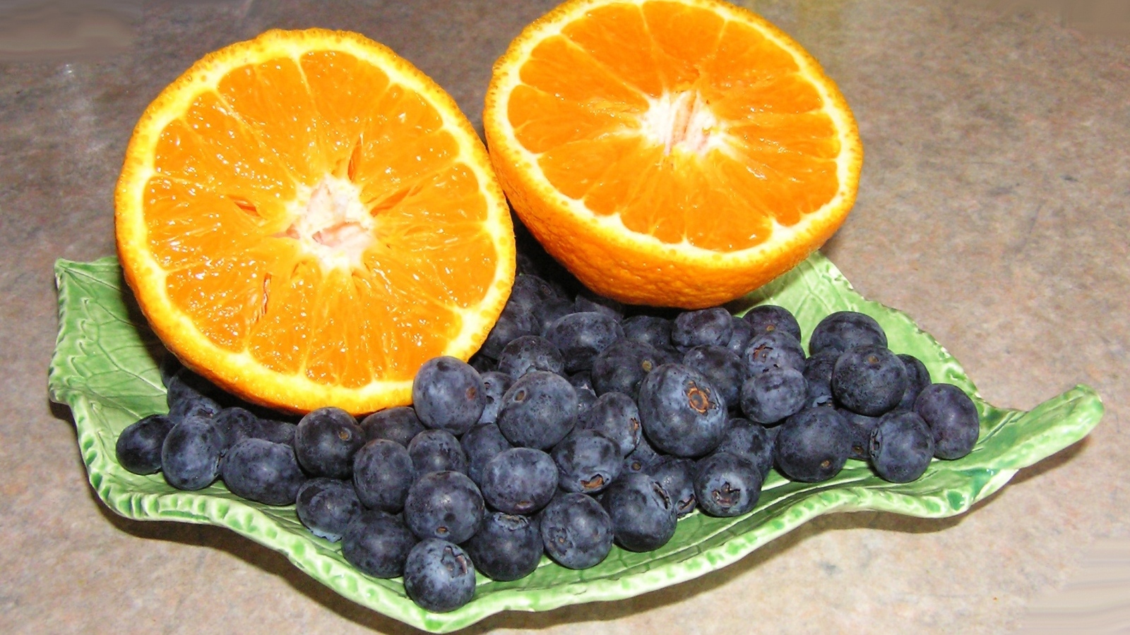 Половинки апельсина с ягодами черники на столе