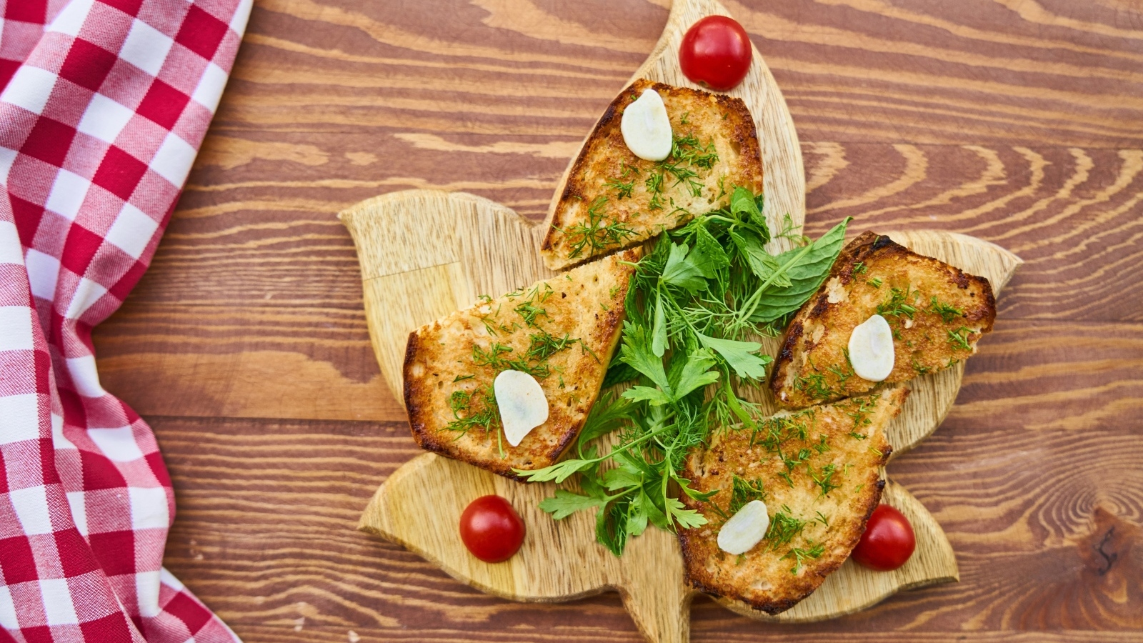 Жареный хлеб на доске с зеленью и помидорами