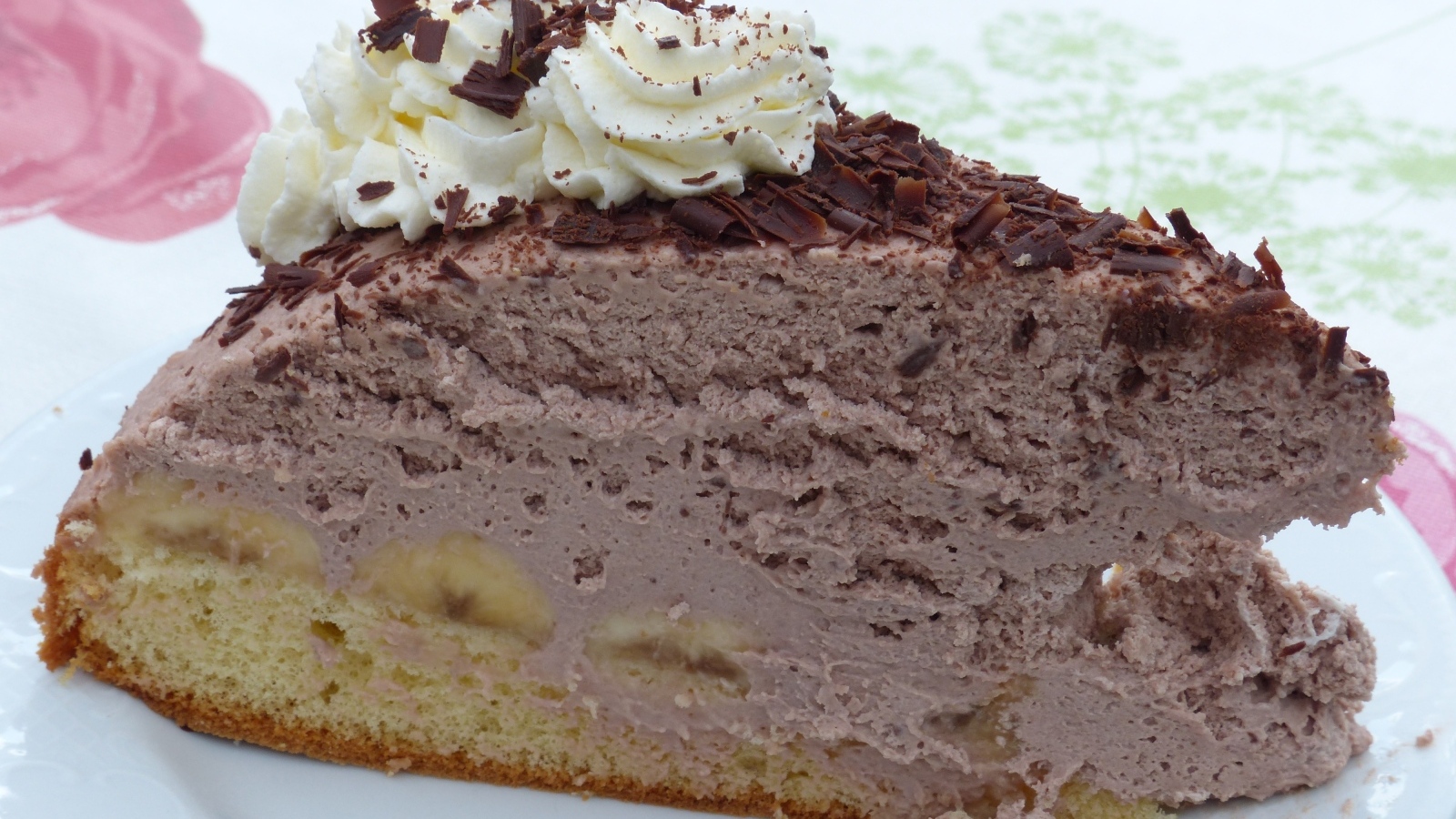 Кусок аппетитного торта с кремом на белой тарелке