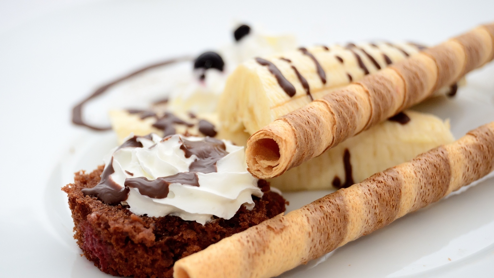 Банан на тарелке с трубочками и кексом