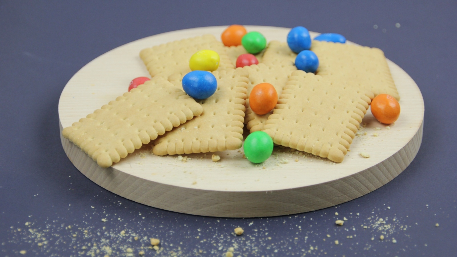 Печенье с разноцветными конфетами на сером фоне