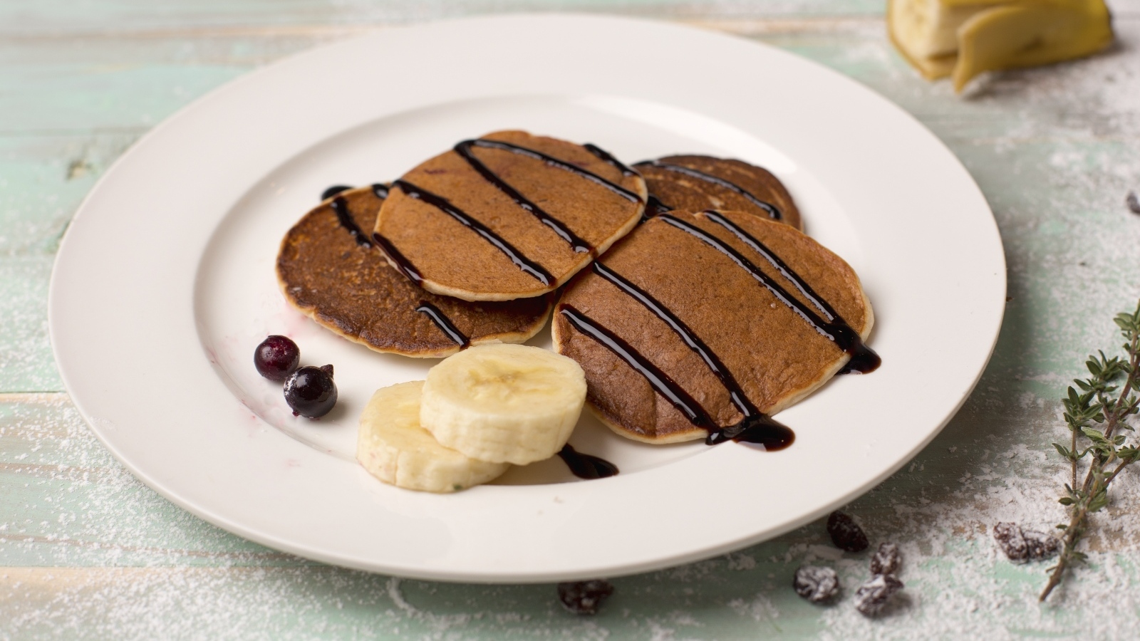 Оладьи на большой белой тарелке с бананами