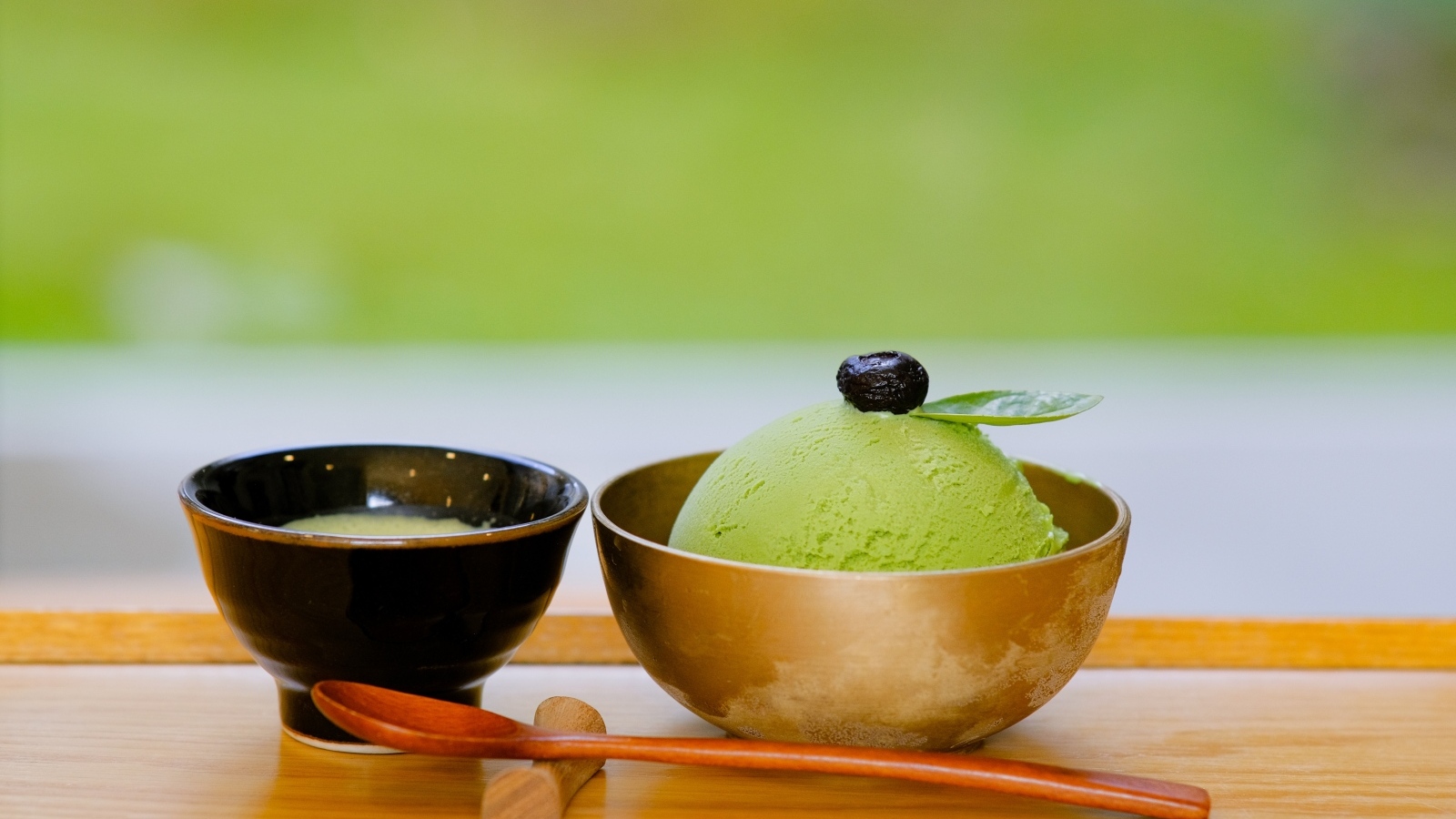 Зеленый шарик мороженого в чашке на столе