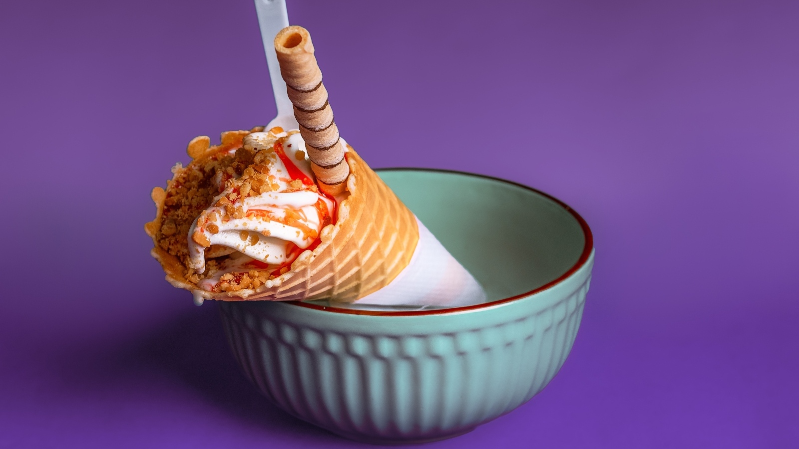 Мороженое рожок с трубочкой на фиолетовом фоне