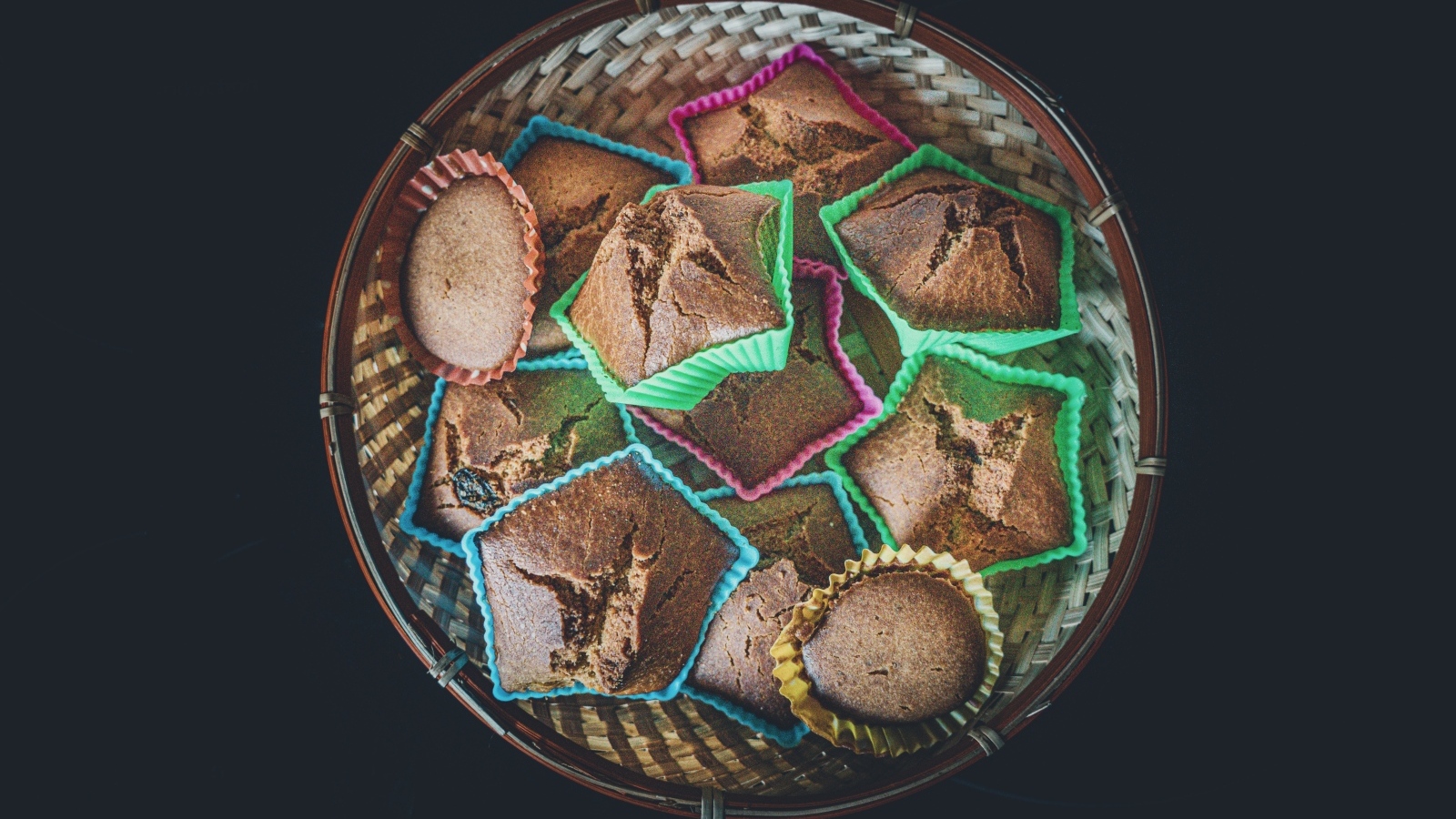 Много кексов в корзине на черном фоне