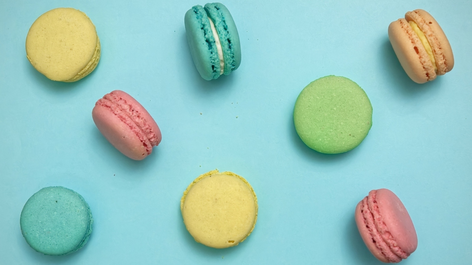 Разноцветный десерт макарон на голубом фоне