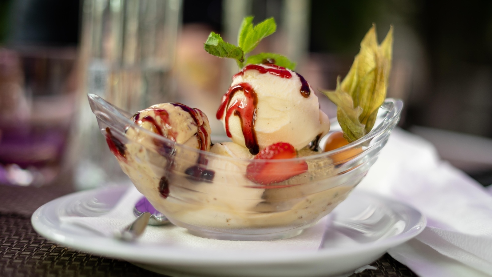 Шарики фруктового мороженого в стеклянной пиале на столе