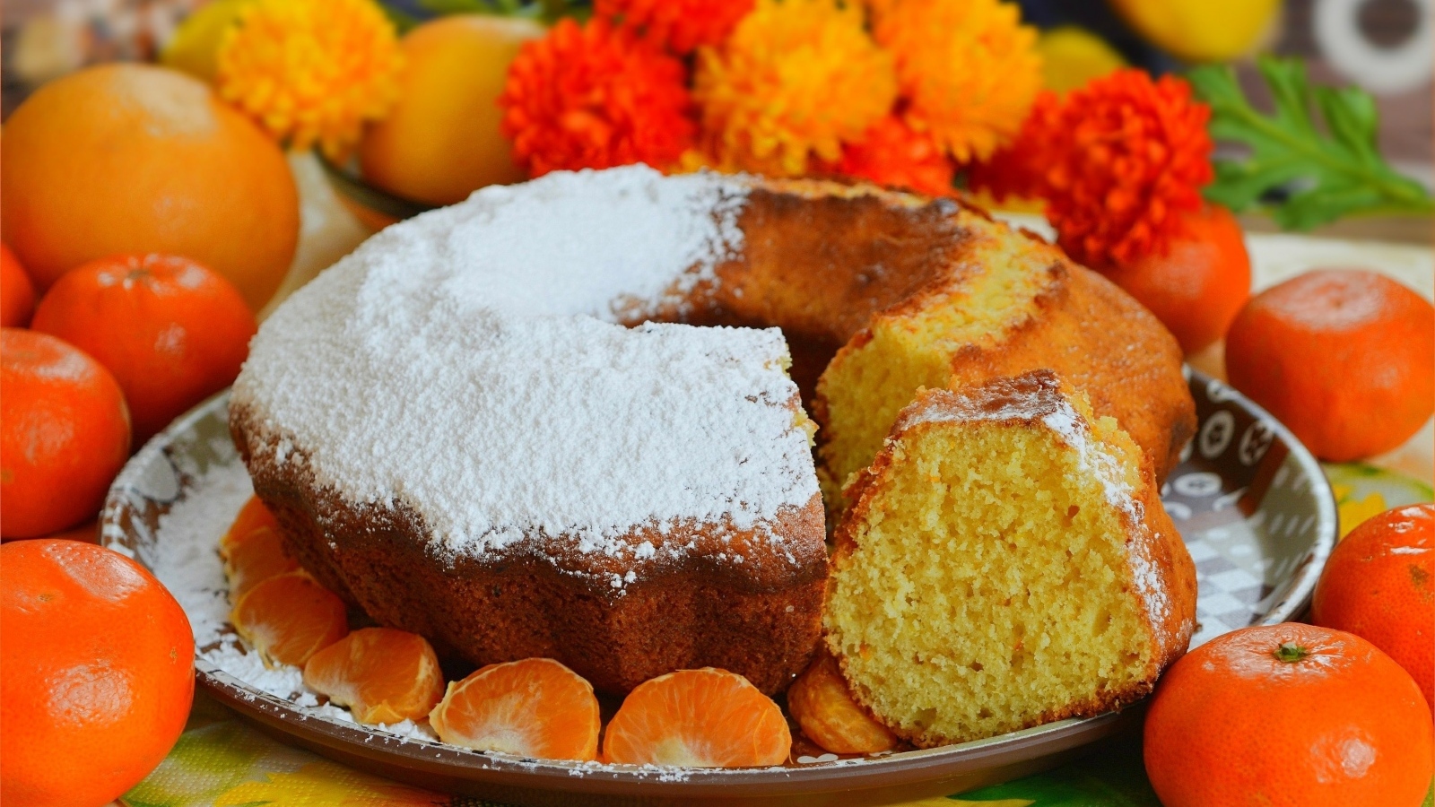 Сладкий пирог на столе с мандаринами и апельсинами