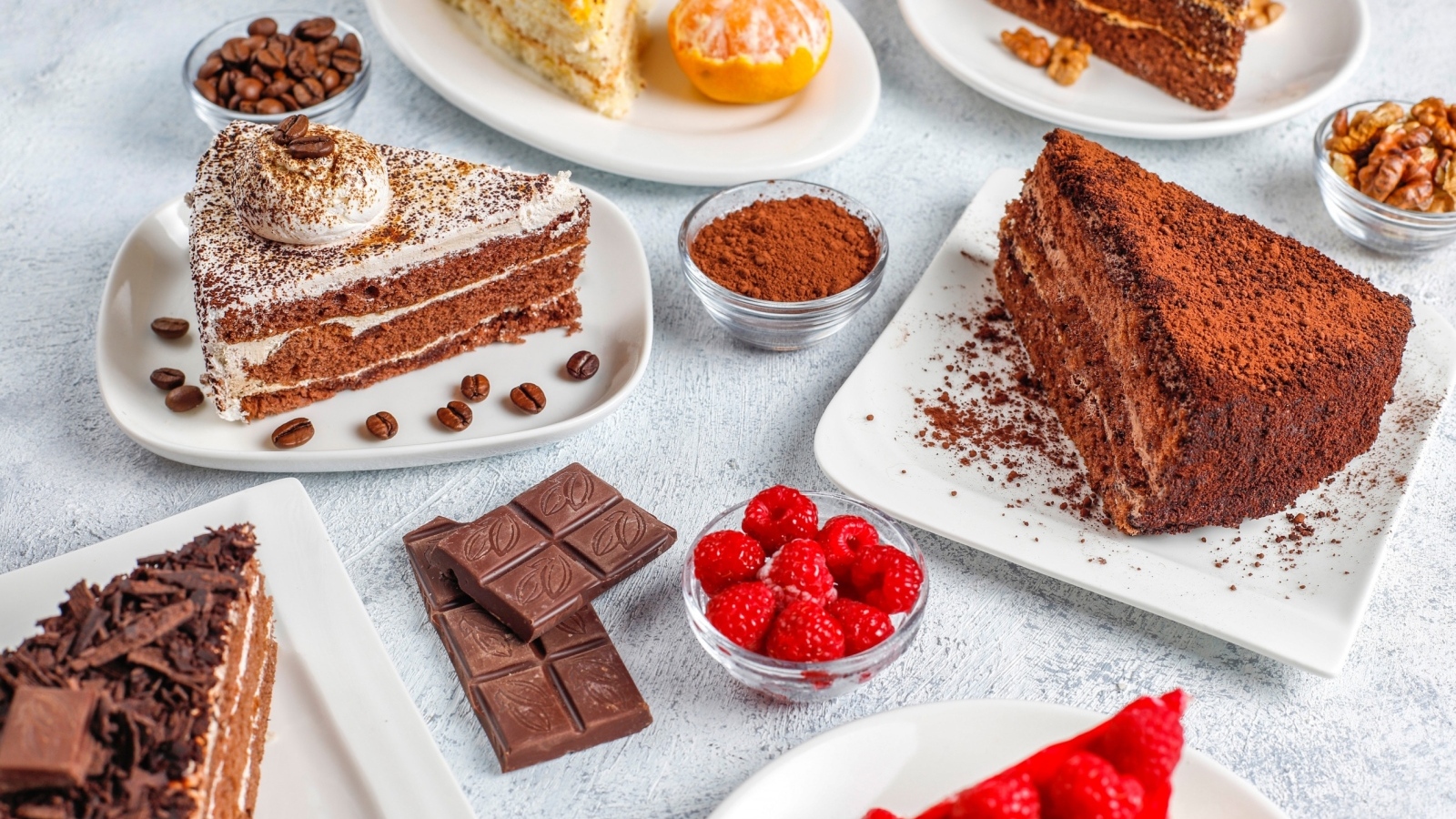 Сладкие куски торта на столе с шоколадом и ягодами