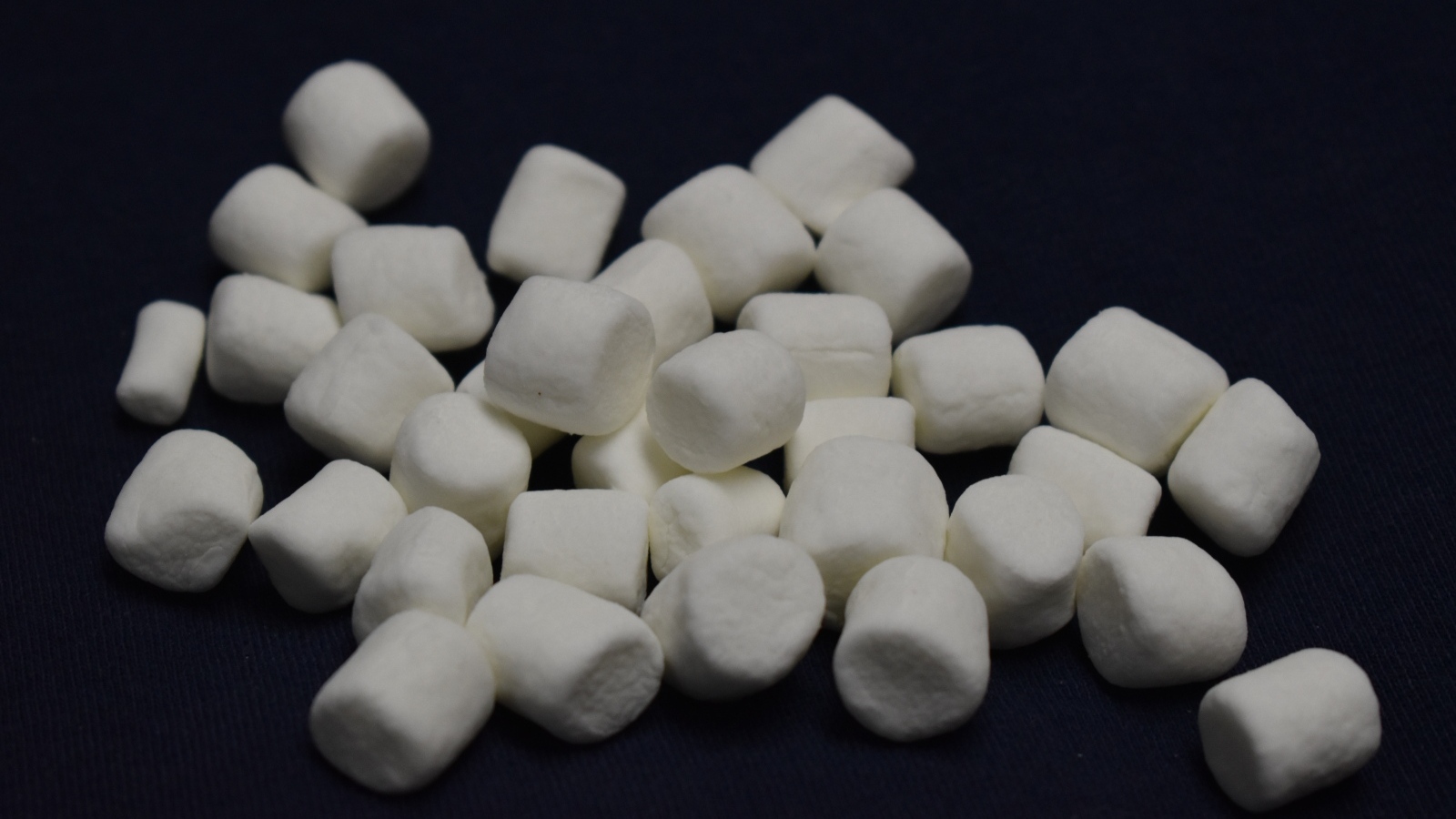 Белое маршмеллоу на черном фоне