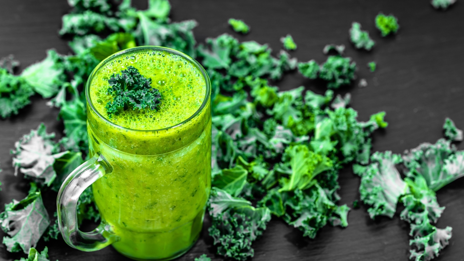 Бокал с зеленым смузи с листьями