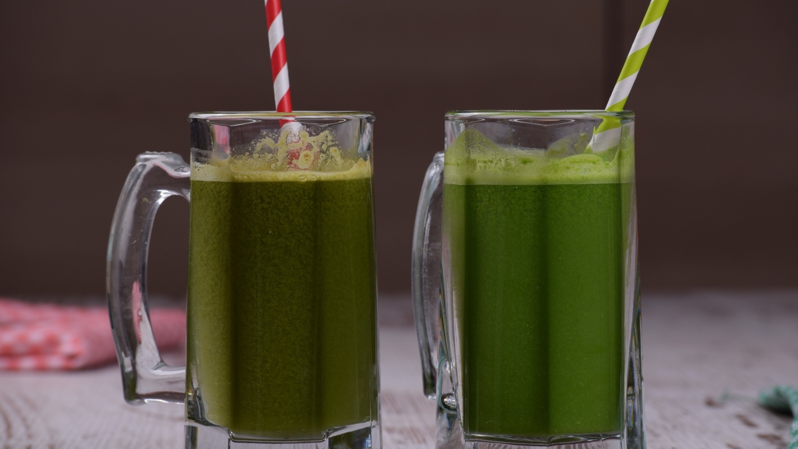 Два стакана зеленого смузи с трубочками