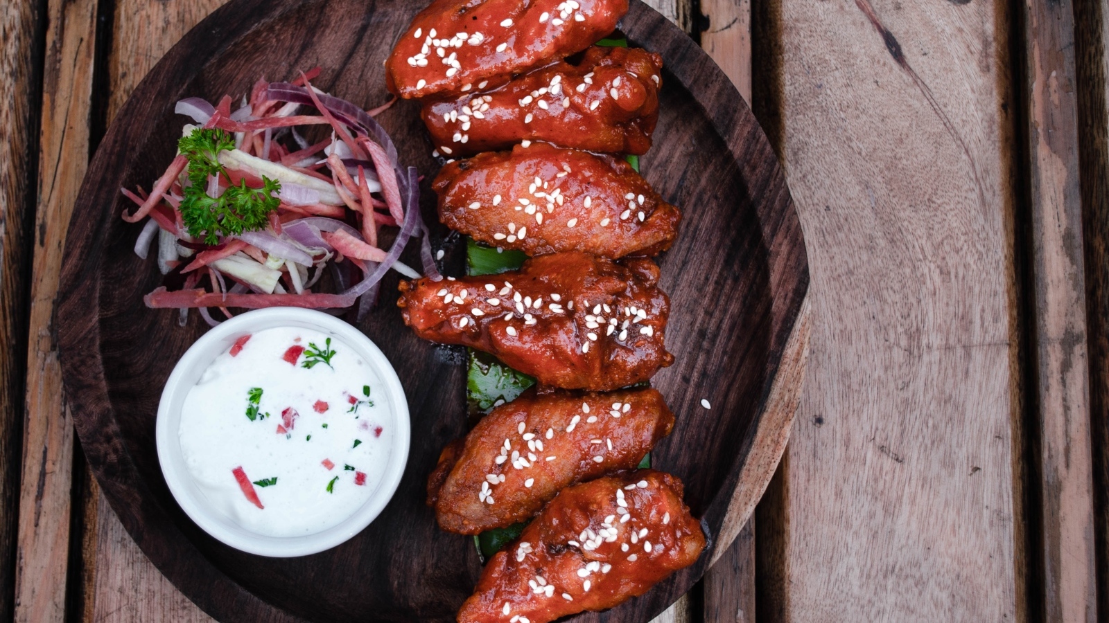 Запеченные куриные крылышки с соусом на тарелке