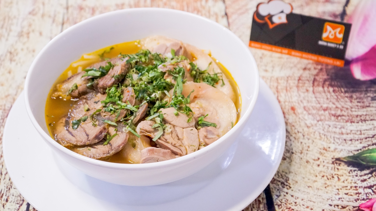 Бульон с мясом в белой тарелке на столе