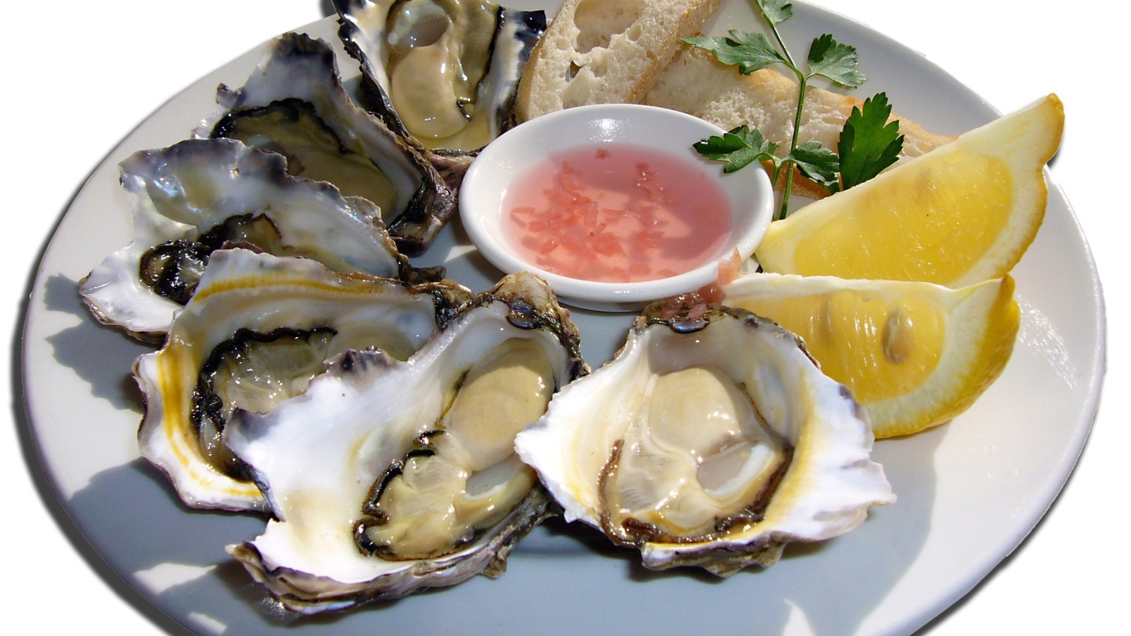 Устрицы  на белой тарелке с лимоном