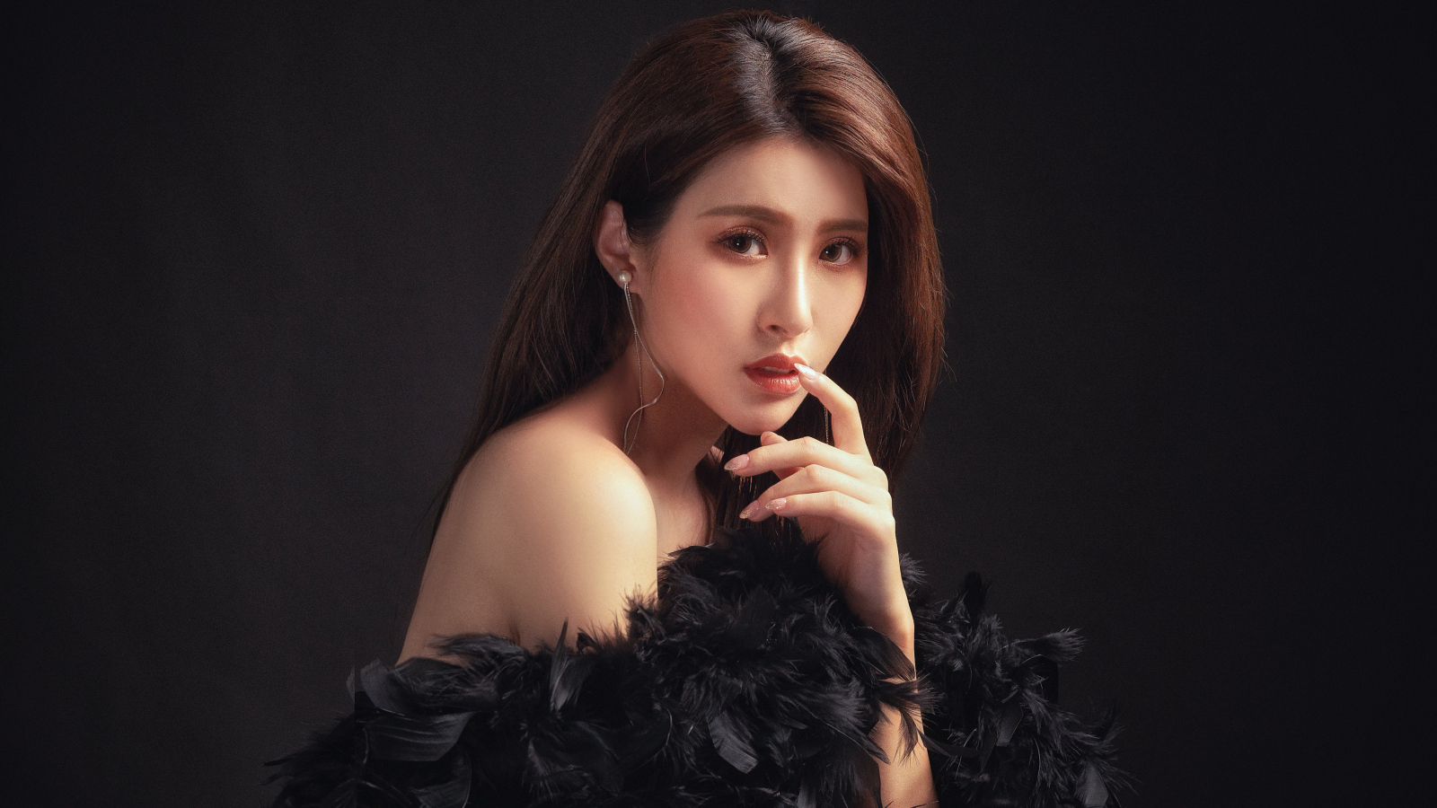 Девушка азиатка в боа на черном фоне