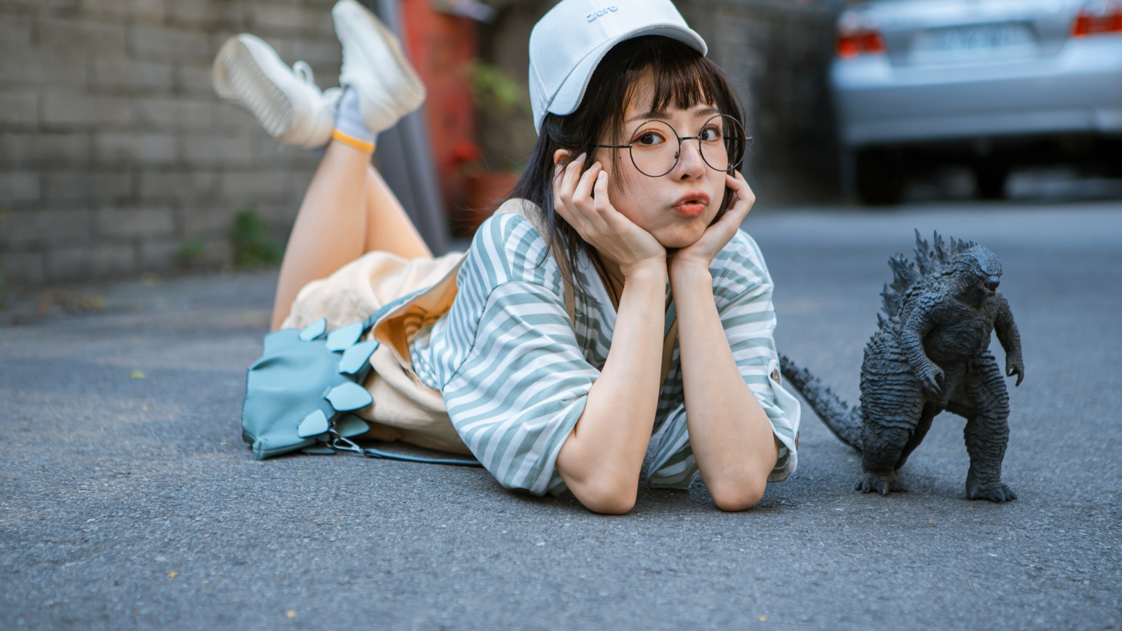 Девушка азиатка с фигуркой годзиллы