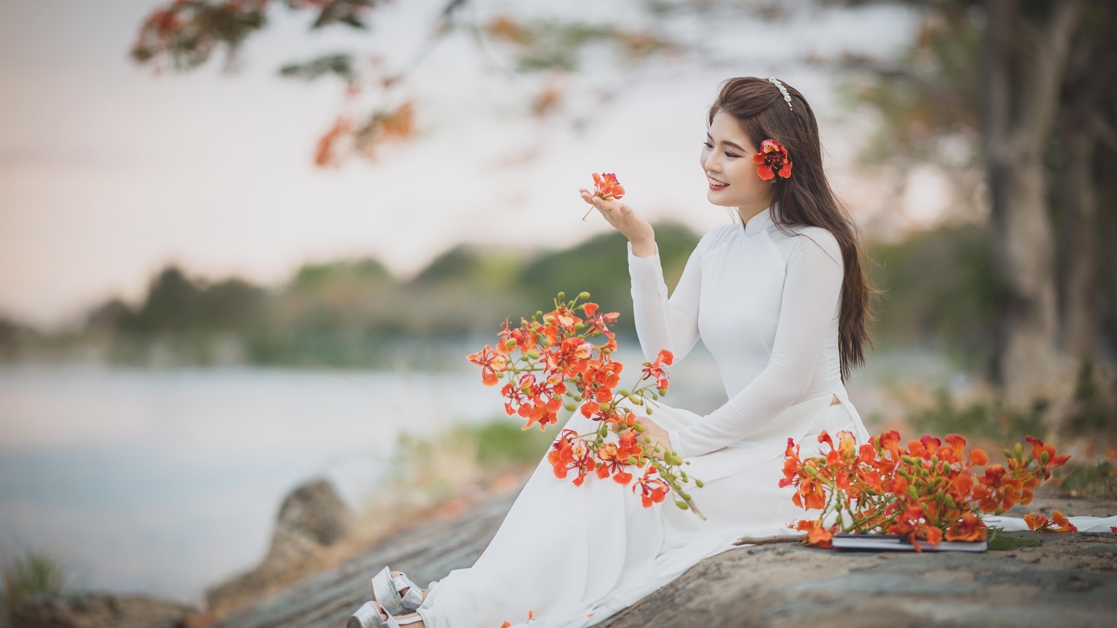 Красивая девушка азиатка в белом платье с цветами в руке