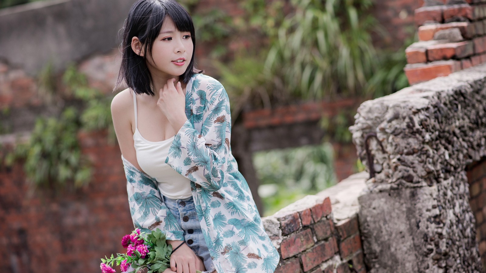 Красивая азиатка с цветком в руке