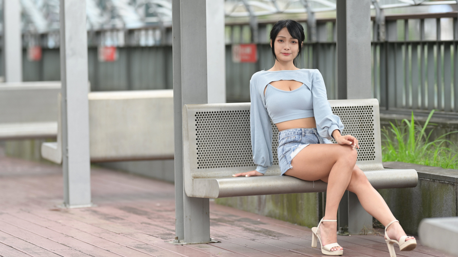 Красивая темноволосая девушка азиатка сидит на лавке
