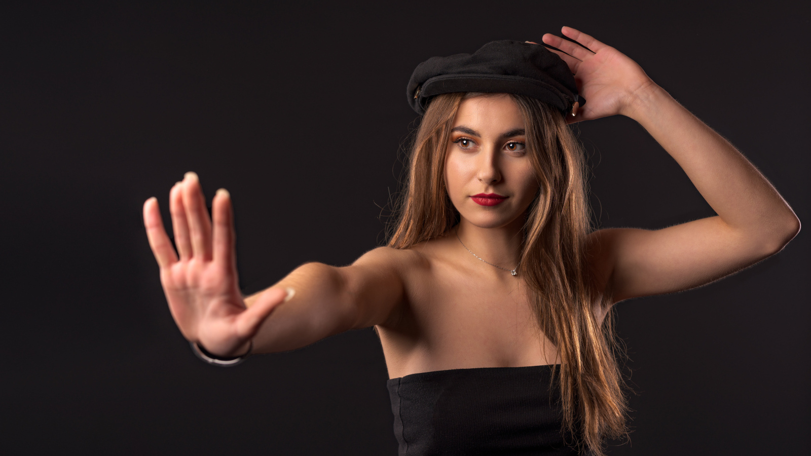 Красивая девушка в кепке на черном фоне