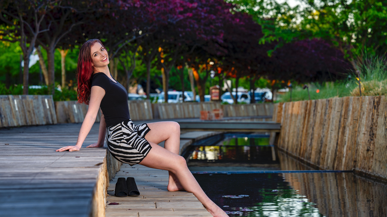 Красивая девушка опустила ноги в воду