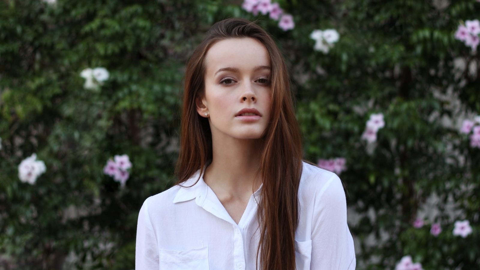 Красивая длинноволосая девушка в белой рубашке