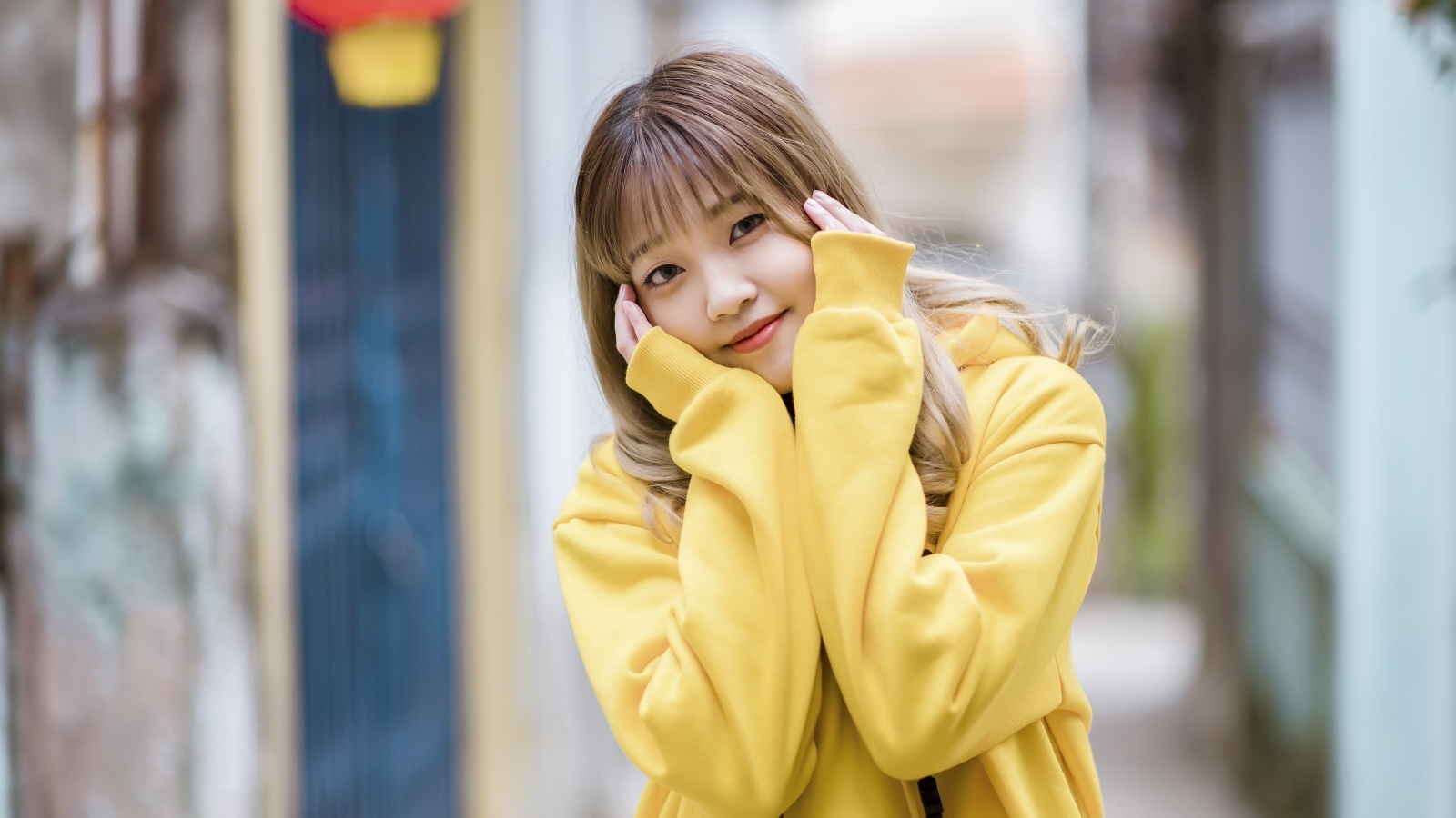 Милая девушка азиатка в желтом свитере