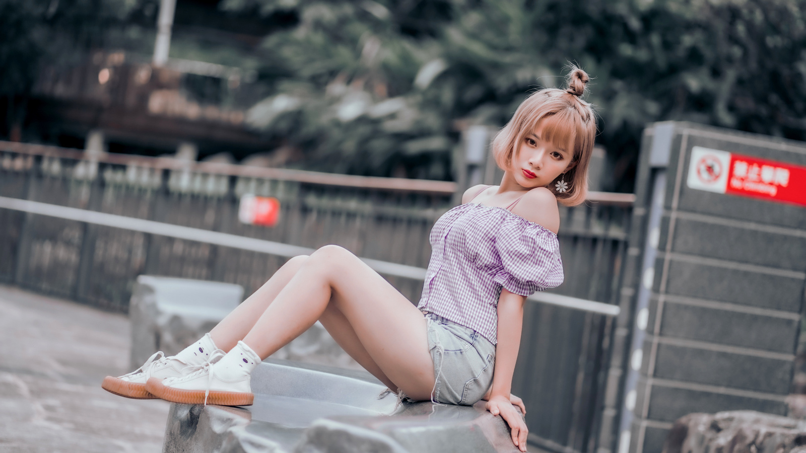 Милая девушка азиатка сидит на камне