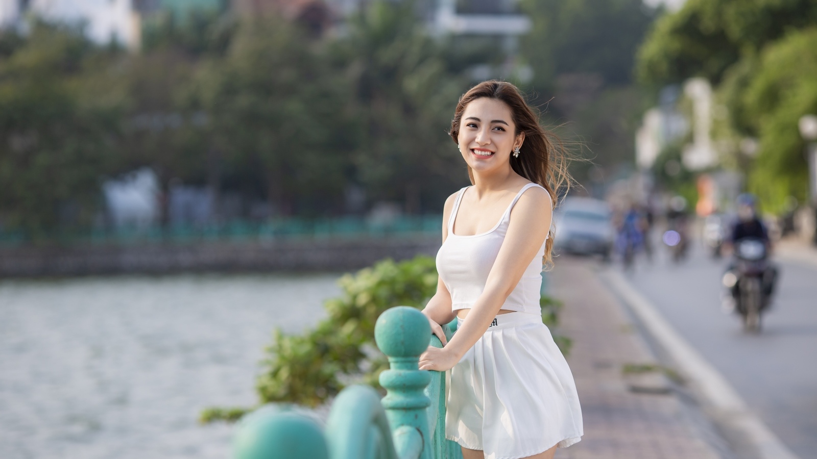 Улыбающаяся девушка азиатка в белом летнем костюме