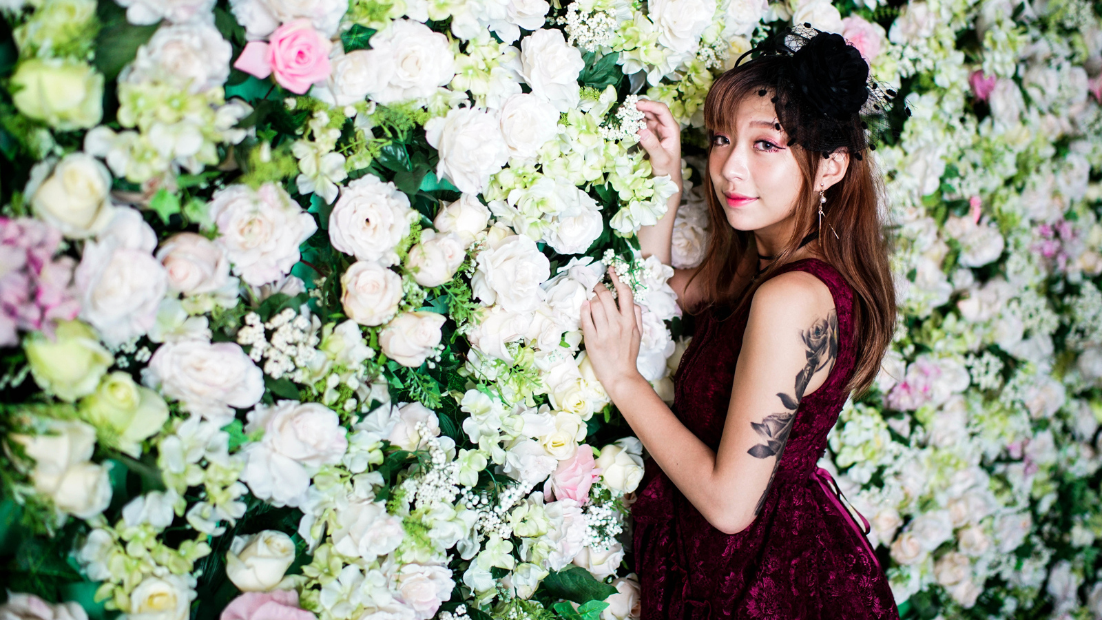 Молодая азиатка на фоне стены с розами