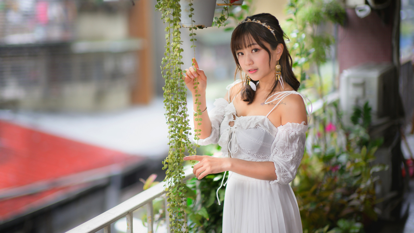 Молодая азиатка в белом платье у растений