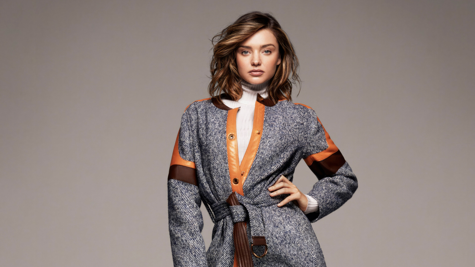 Стильная молодая модель Миранда Керр в пальто на сером фоне