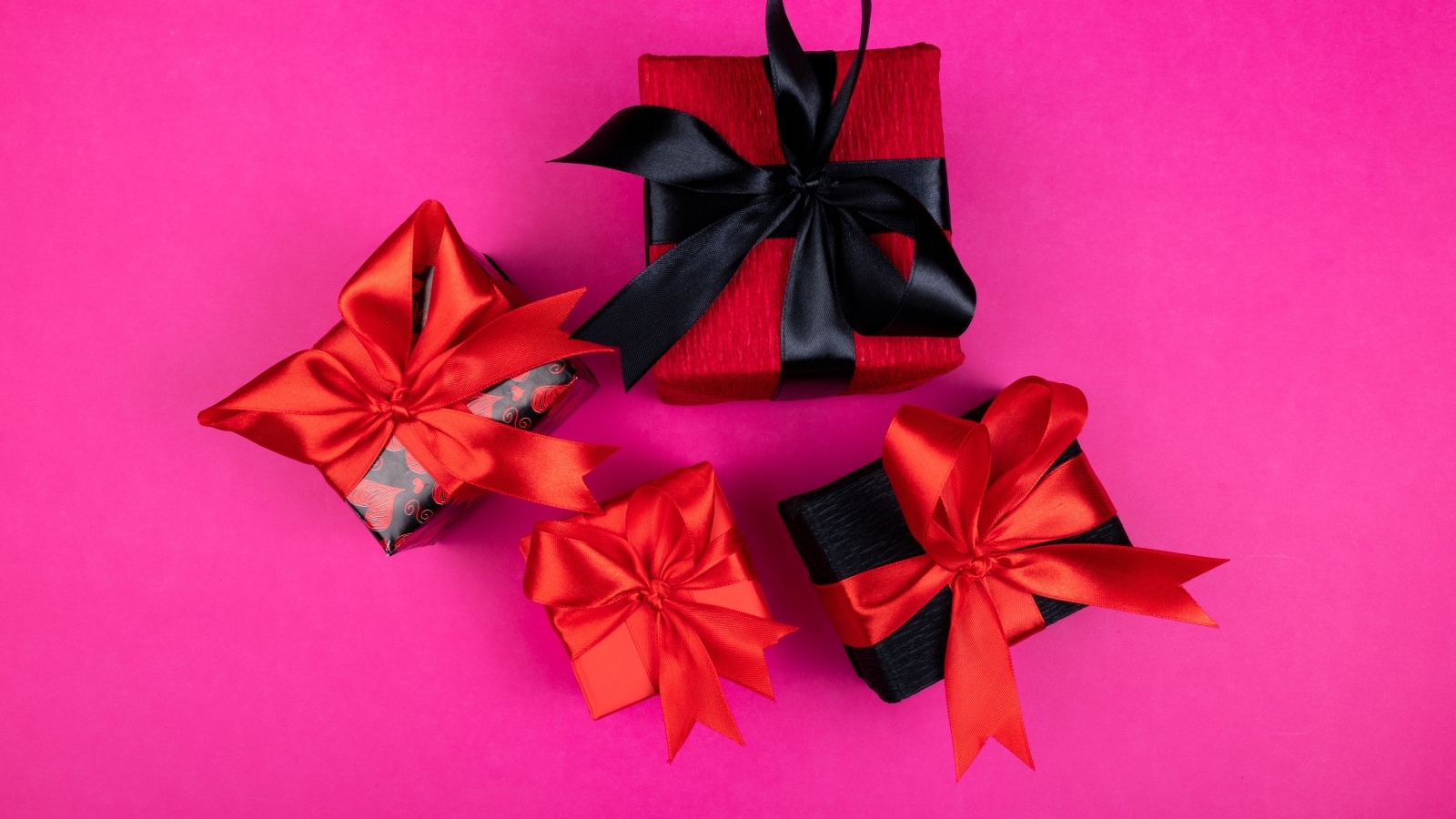 Коробки с подарками и яркими бантами на розовом фоне